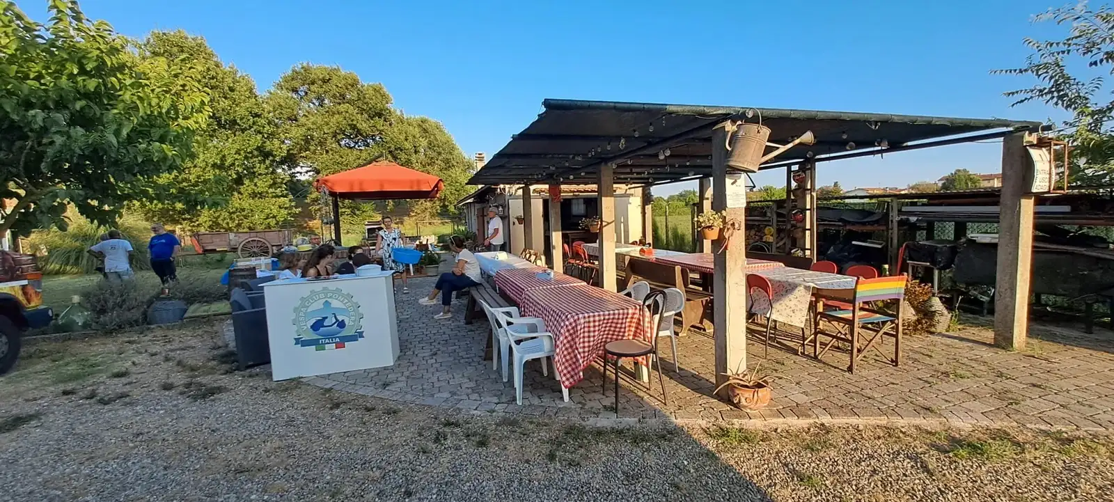 Tavoli sotto un pergolato, pronti per la serata