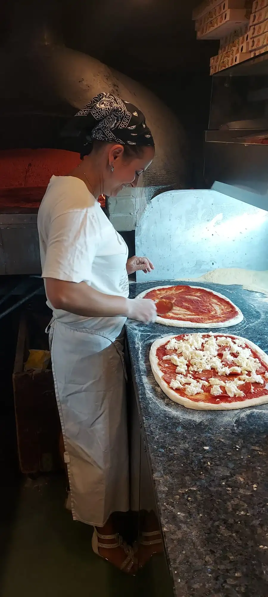 Al banco di marmo, mentre si condisce una pizza