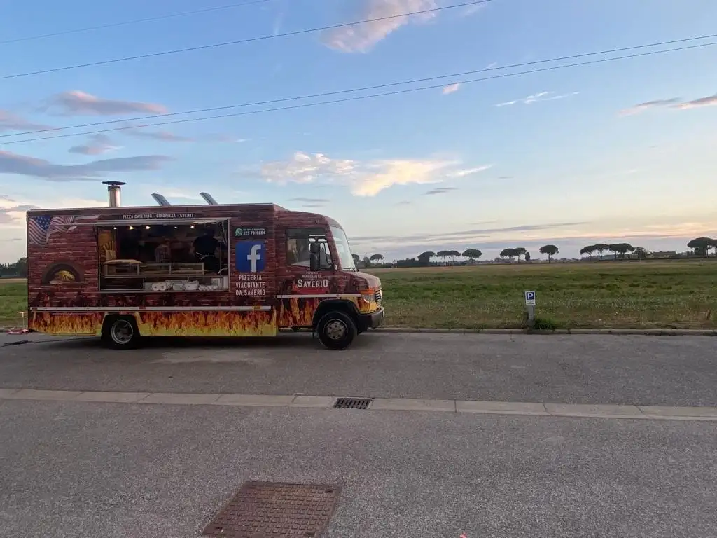 Il camion di profilo su una strada di campagna al tramonto, con il banco aperto